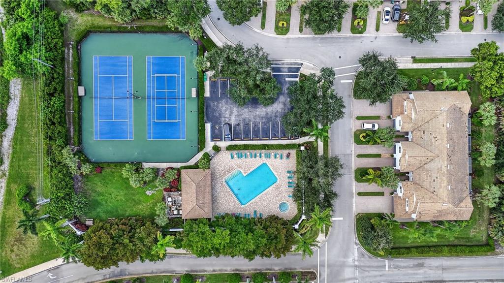 Community amenities featuring a swimming pool with surrounding patio, two tennis courts, and mature landscaping