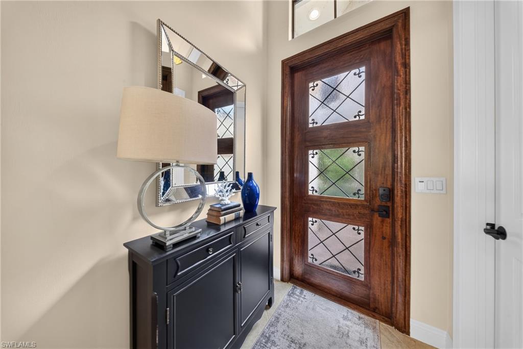 Rich wood entry door featuring decorative glass panels and dark hardware