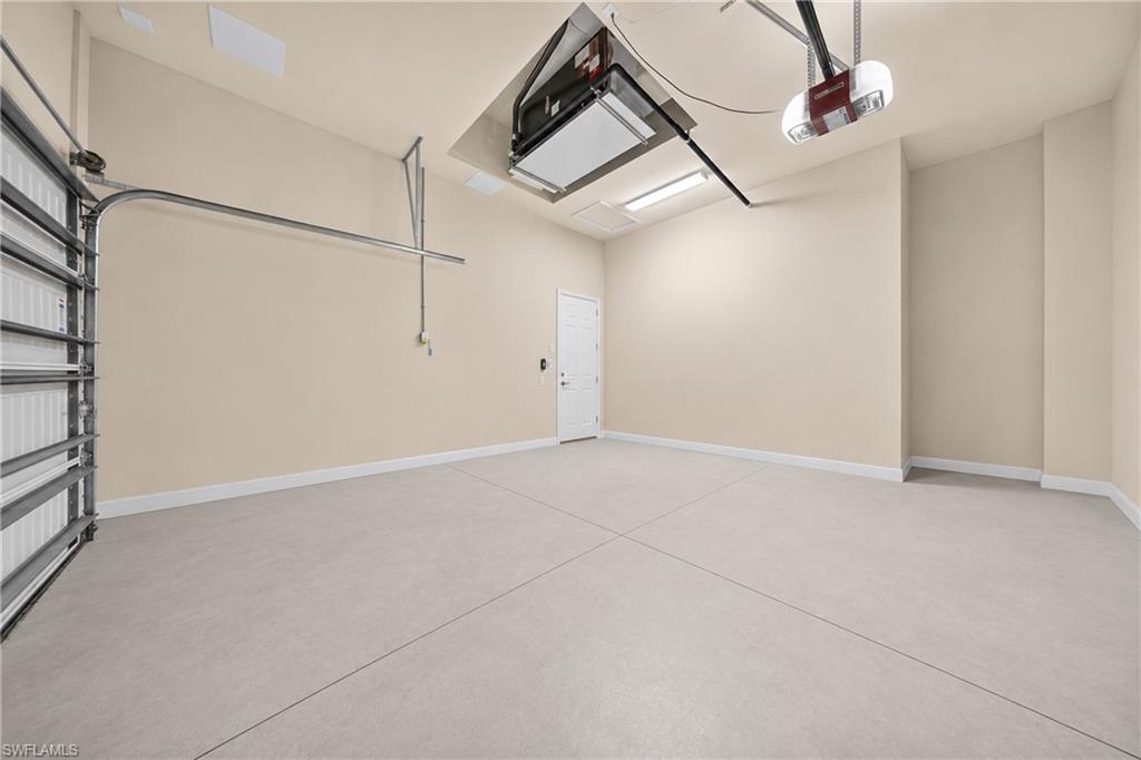 Spacious garage featuring a light neutral wall color and concrete flooring