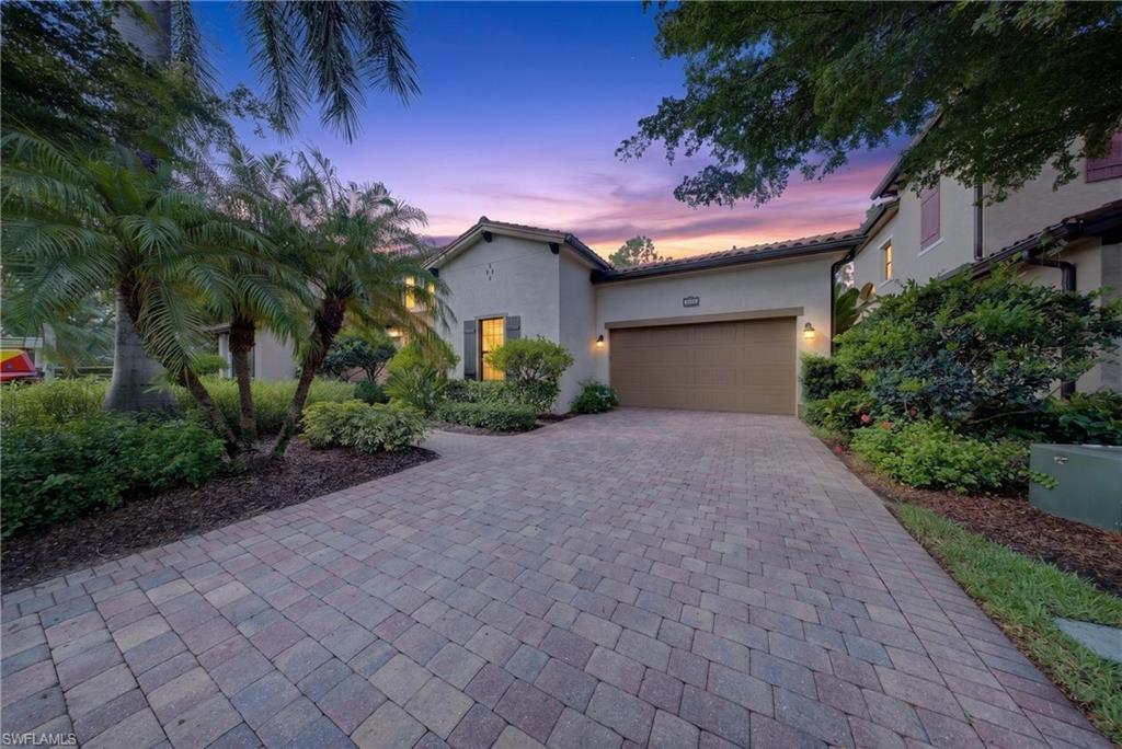 Stucco exterior residence with a tile roof and an integrated garage
