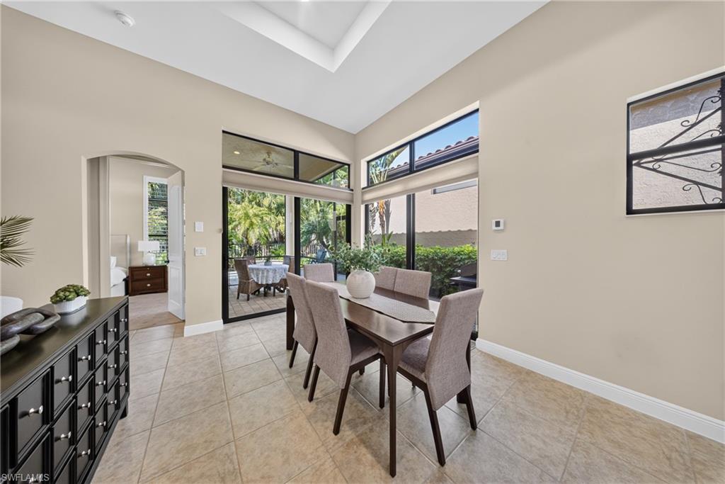 Dining area featuring tile flooring, a tray ceiling, and sliding glass doors with transom windows