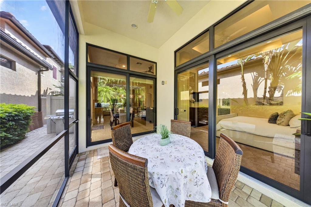 Screened patio featuring a ceiling fan, paver flooring, and multiple sliding glass doors