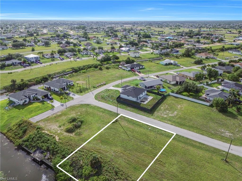 Expansive green lot with established road access, bordering a natural waterway