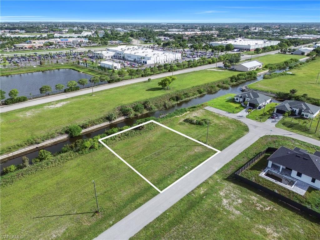 Cleared lot with direct road frontage, surrounded by expansive green spaces