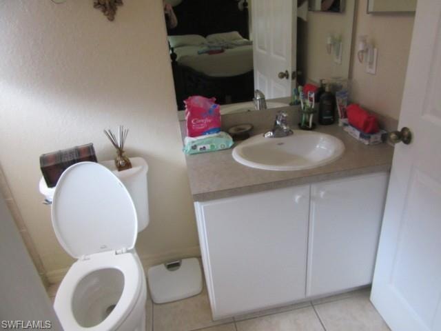 Bathroom with a white vanity featuring double cabinet doors, an integrated sink, and a light-toned countertop