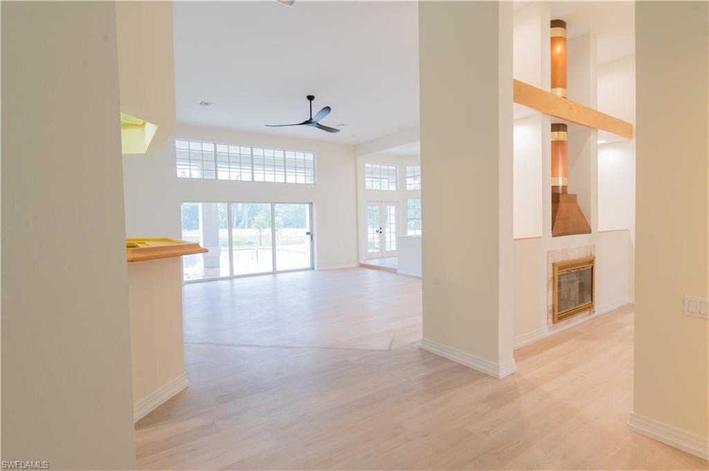 Room featuring wood-finish flooring, a window with plantation shutters, and a contemporary ceiling fan