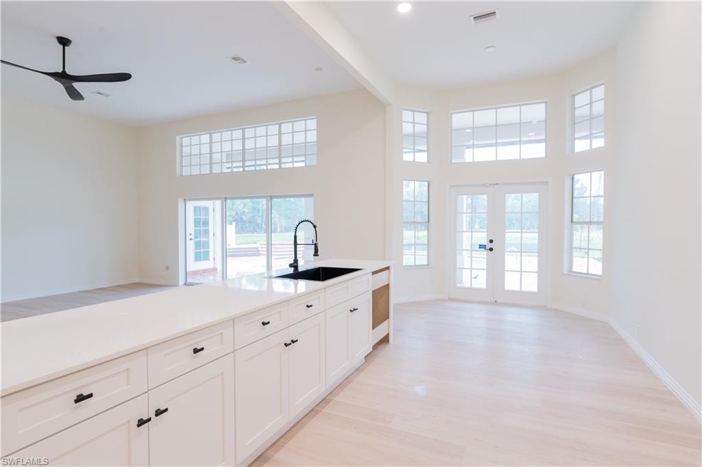 Open-concept interior featuring light wood-finish flooring and white walls