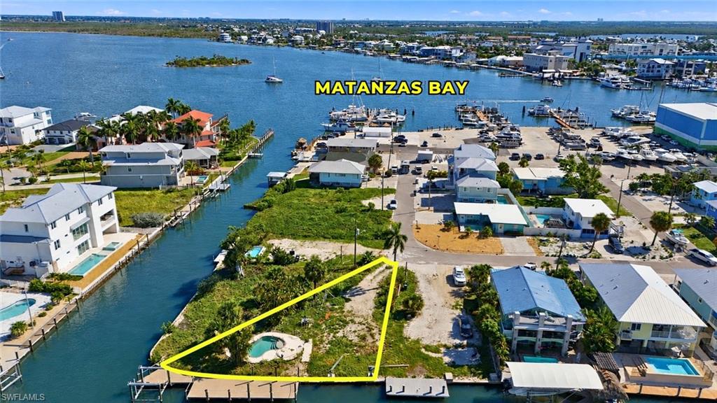 Waterfront lot with canal access featuring a private dock and a small pool - Virtually Edited Image