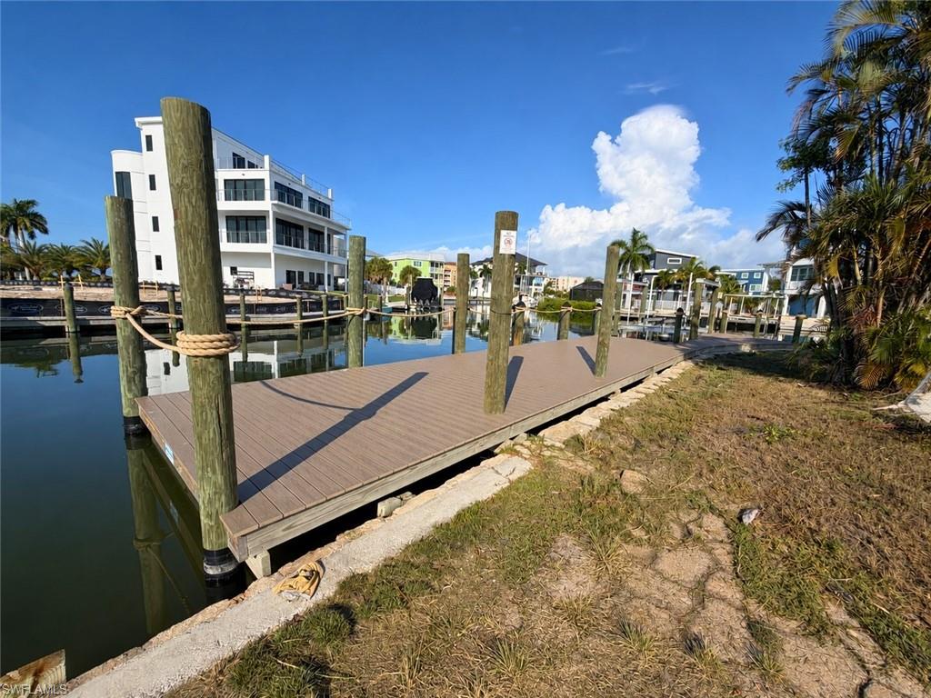 Private boat dock featuring composite decking, multiple pilings with rope accents, and direct water access - Virtually Edited Image