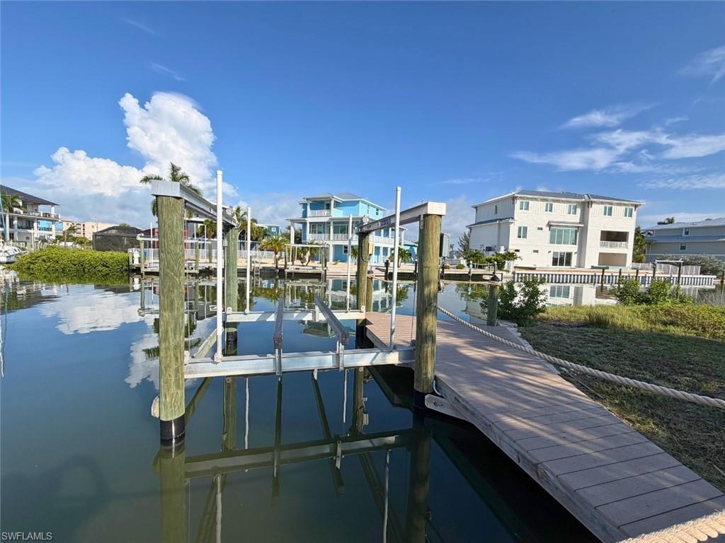 Private boat slip with a built-in boat lift, composite decking, and a rope railing - Virtually Edited Image