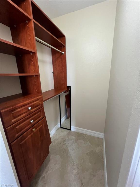 Spacious closet featuring light tile flooring