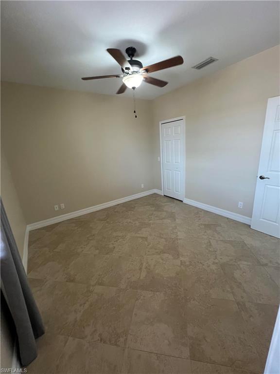 Unfurnished bedroom with ceiling fan, tile flooring, and a closet