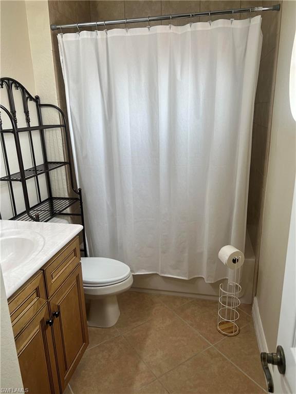 Full bathroom featuring tile floors, shower / bath combination with curtain, toilet, and vanity