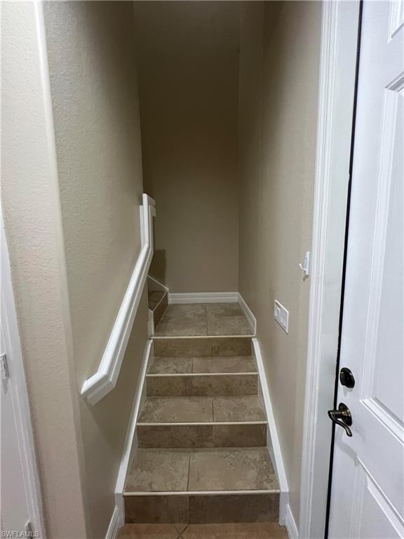 Stairway featuring dark tile floors