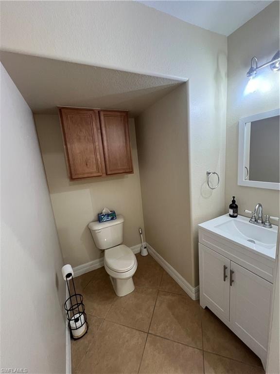 1/2 Bathroom with tile floors, toilet, and vanity