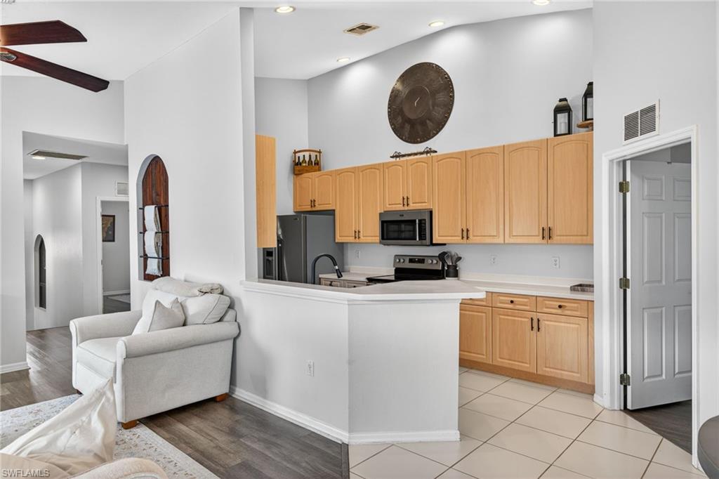 Kitchen featuring light wood-finish cabinetry, white countertops, and stainless steel appliances