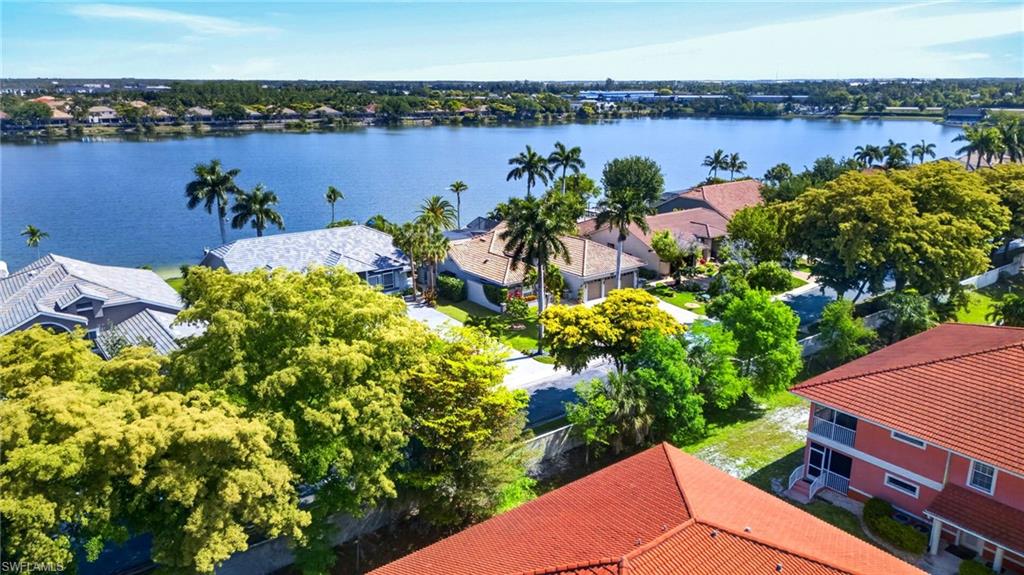Waterfront properties featuring mature landscaping and tiled roofs