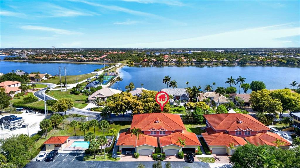 Waterfront property featuring terracotta tile roofing, attached garages, and a private swimming pool
