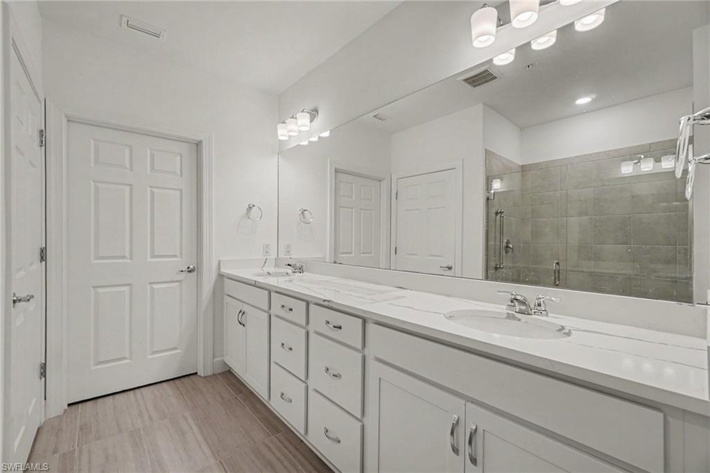 Double vanity with white cabinetry, integrated sinks, and a full-width mirror