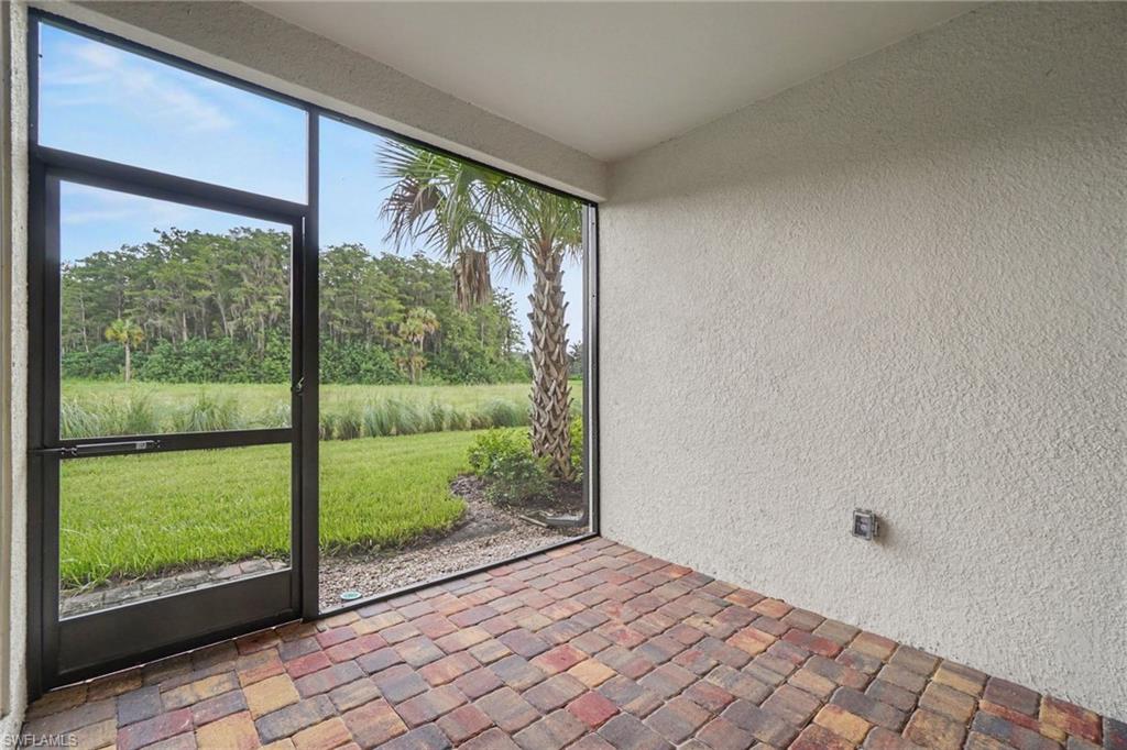 Screened patio with multi-toned paver flooring and textured stucco walls
