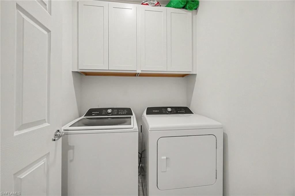 Laundry area featuring white shaker-style cabinetry, a top-load washing machine, and a front-load dryer