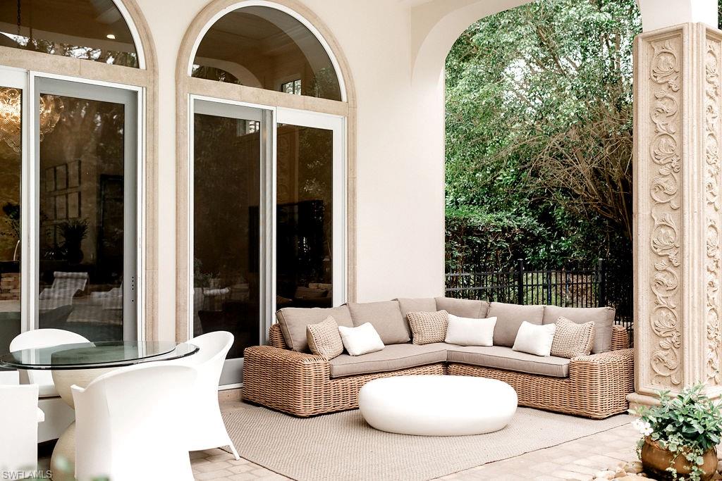 Covered patio featuring an arched entryway and decorative column
