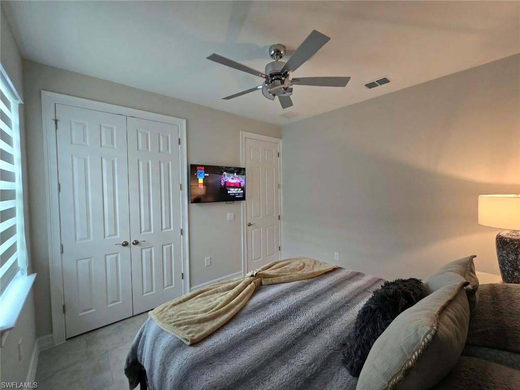 Double-door closet, ceiling fan, wall-mounted television, and hard-surface flooring