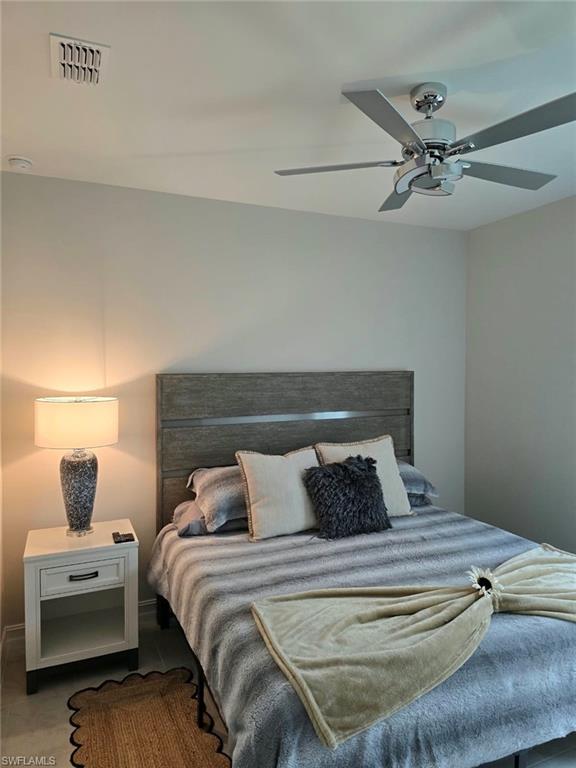 Ceiling fan with brushed nickel finish, recessed lighting, and wood-finish headboard