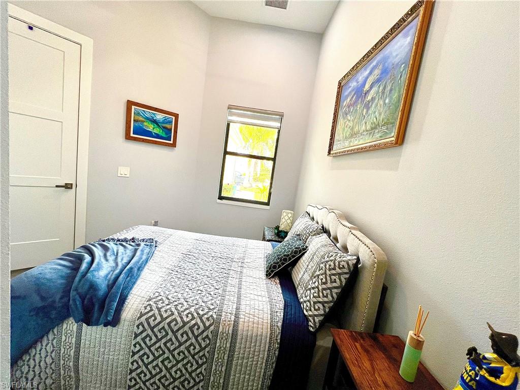 Room with high vaulted ceiling, light neutral wall paint, and a window with roller shades