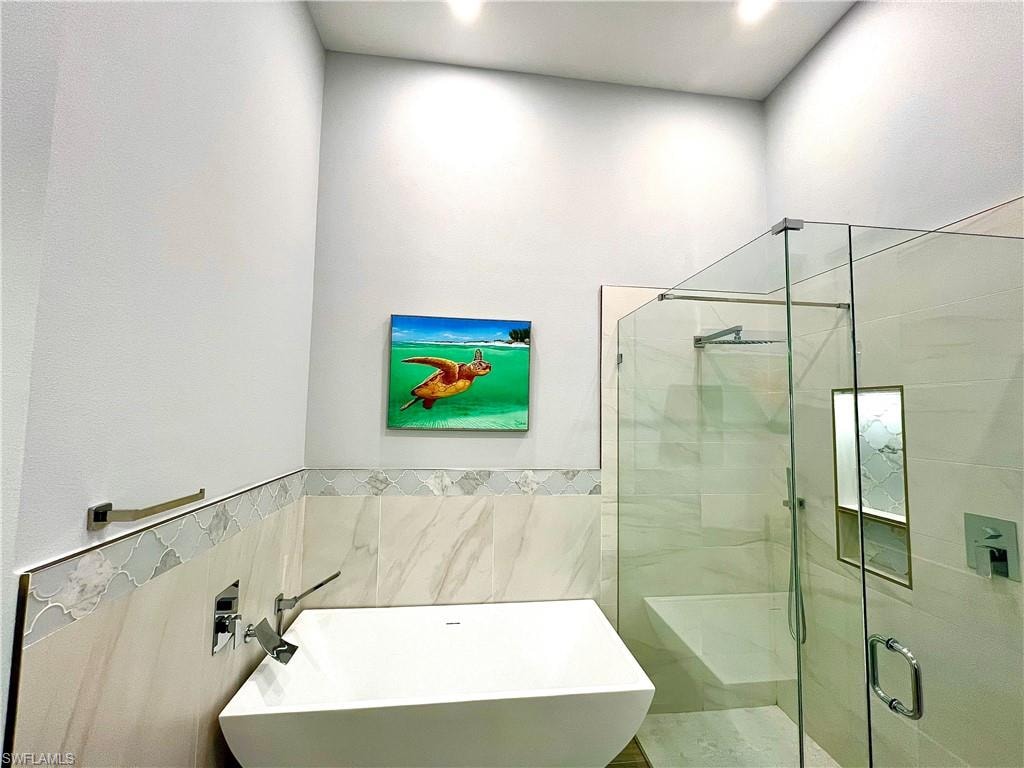 Contemporary bathroom featuring a freestanding soaking tub with wall-mounted fixtures