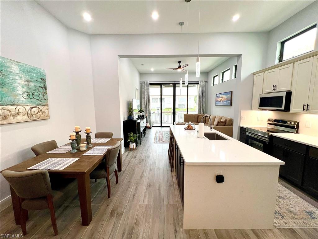 Open-concept living space featuring high ceilings, wood-finish flooring, and recessed lighting