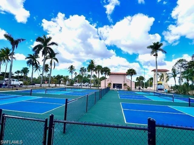 Multiple pickleball courts featuring blue and green surfaces, surrounded by chain link fencing