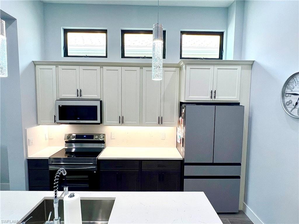 Contemporary kitchen showcasing white upper cabinetry and dark lower cabinetry with coordinating hardware