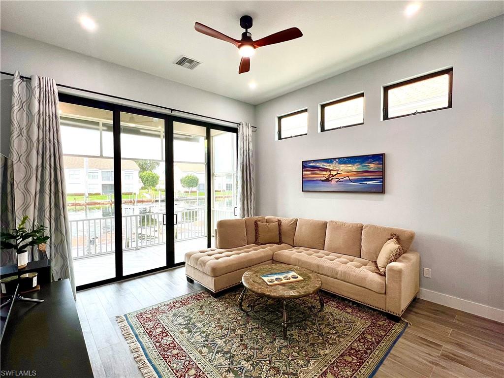 Expansive sliding glass doors open to a balcony with white railings