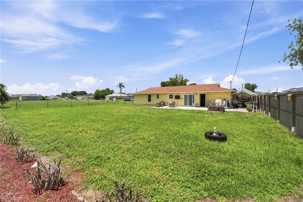 Expansive green space featuring a fenced perimeter
