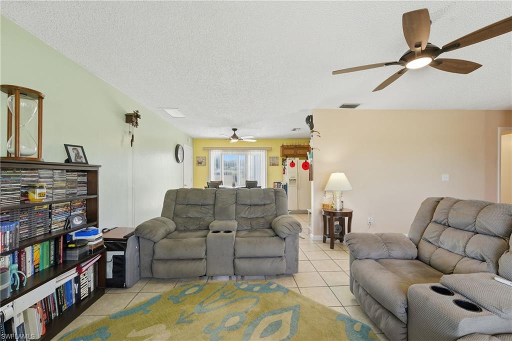 Open concept living area featuring tile flooring, a sloped ceiling, and an overhead ceiling fan