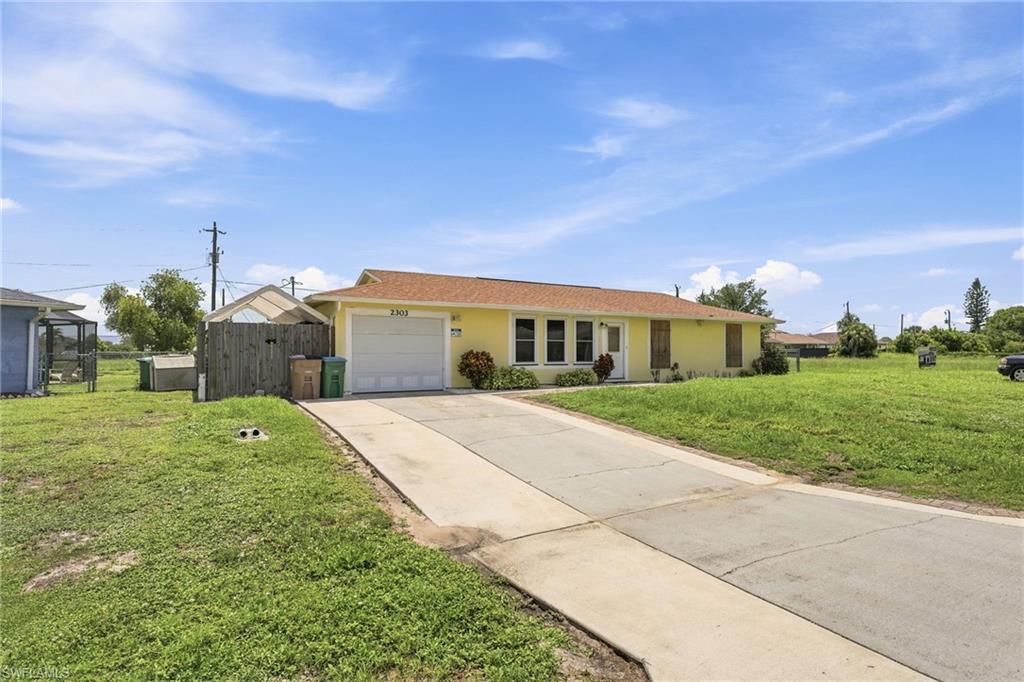 Yellow exterior with a brown shingle roof and an attached garage