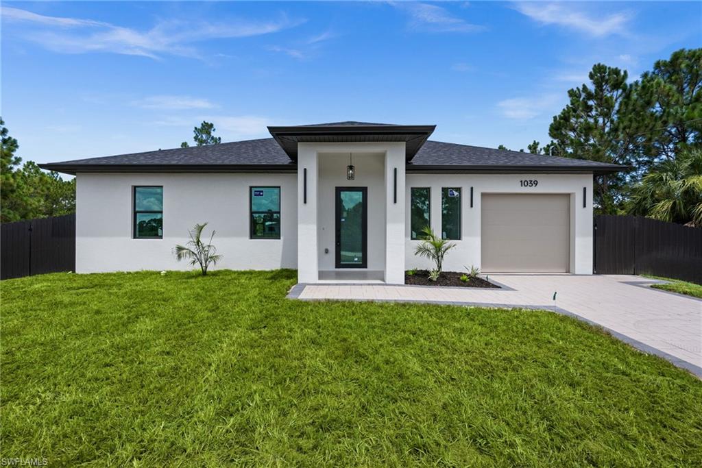Modern-style stucco exterior featuring a dark asphalt shingle roof and black-framed windows