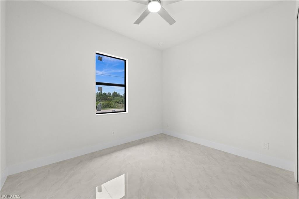 Bright interior room featuring a large window with black trim, tile flooring, recessed lighting, and a ceiling fan