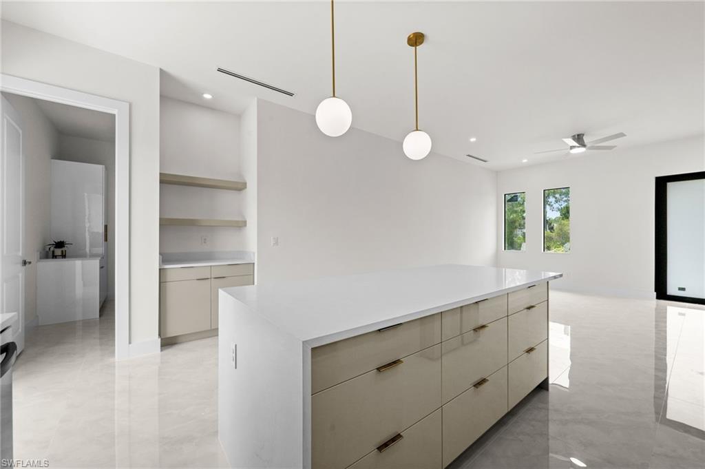 Central kitchen island featuring a light-toned countertop and integrated cabinetry