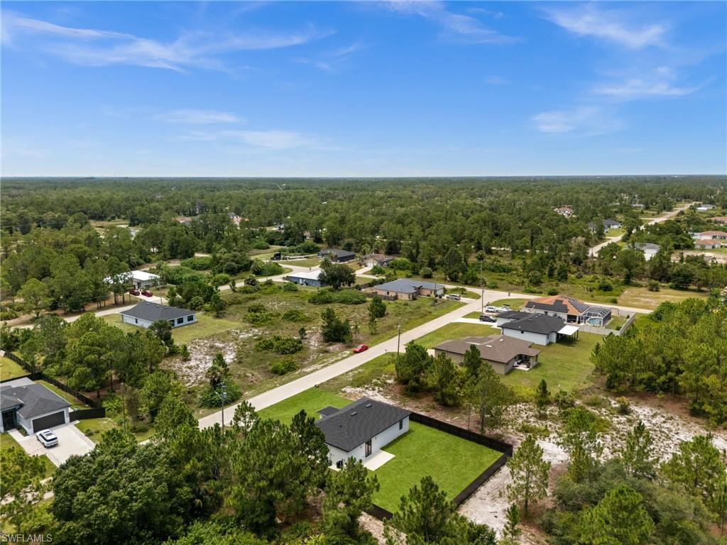 Aerial perspective showcasing a residential area with varied housing styles and extensive surrounding woodlands
