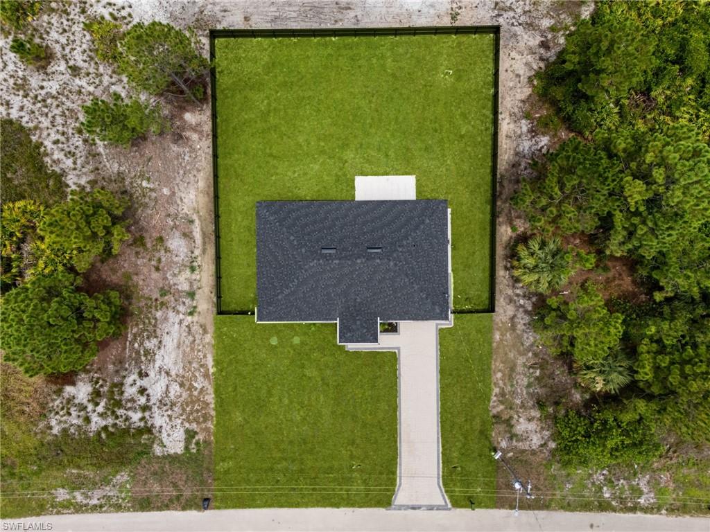 Newly constructed residence featuring a dark shingle roof and a concrete driveway
