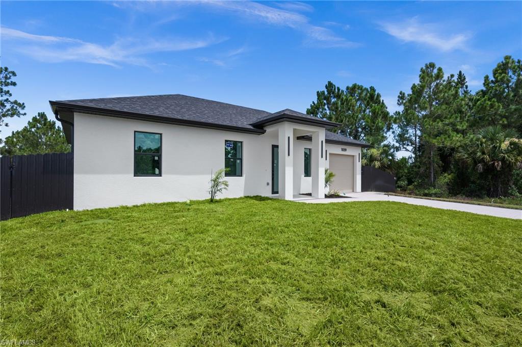 Contemporary single-story residence with a stucco exterior, dark shingle roof, and a two-car garage