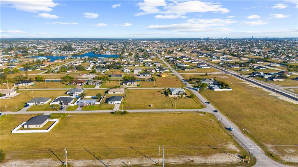 Aerial perspective showcasing multiple residential properties and undeveloped land parcels