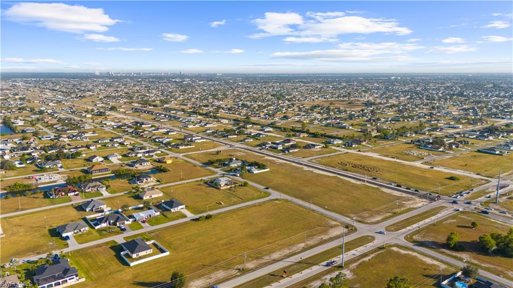 Expansive aerial capturing a suburban landscape with a mix of developed residential areas and undeveloped land parcels