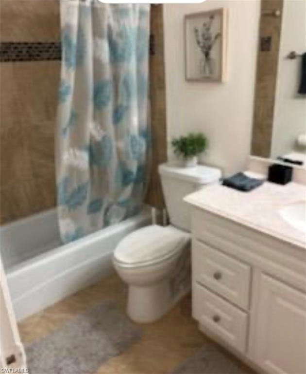 Full bath with vanity, shower / bath combination with curtain, and toilet