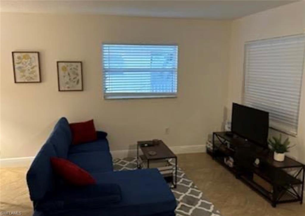 Living room with baseboards and carpet