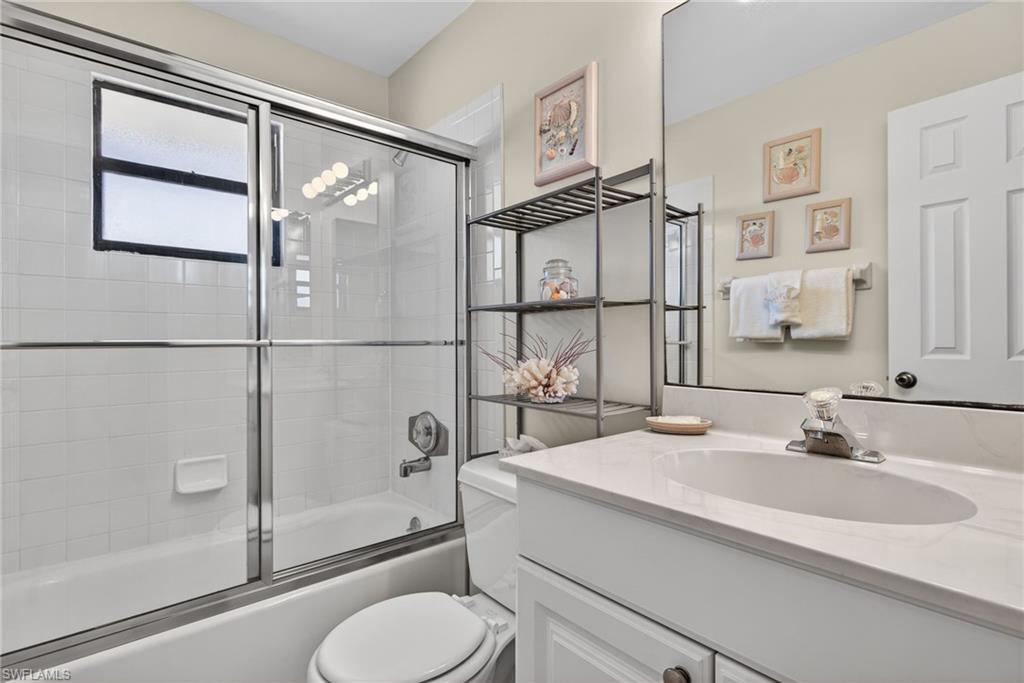 Bathroom featuring vanity and shower / bath combination with glass door