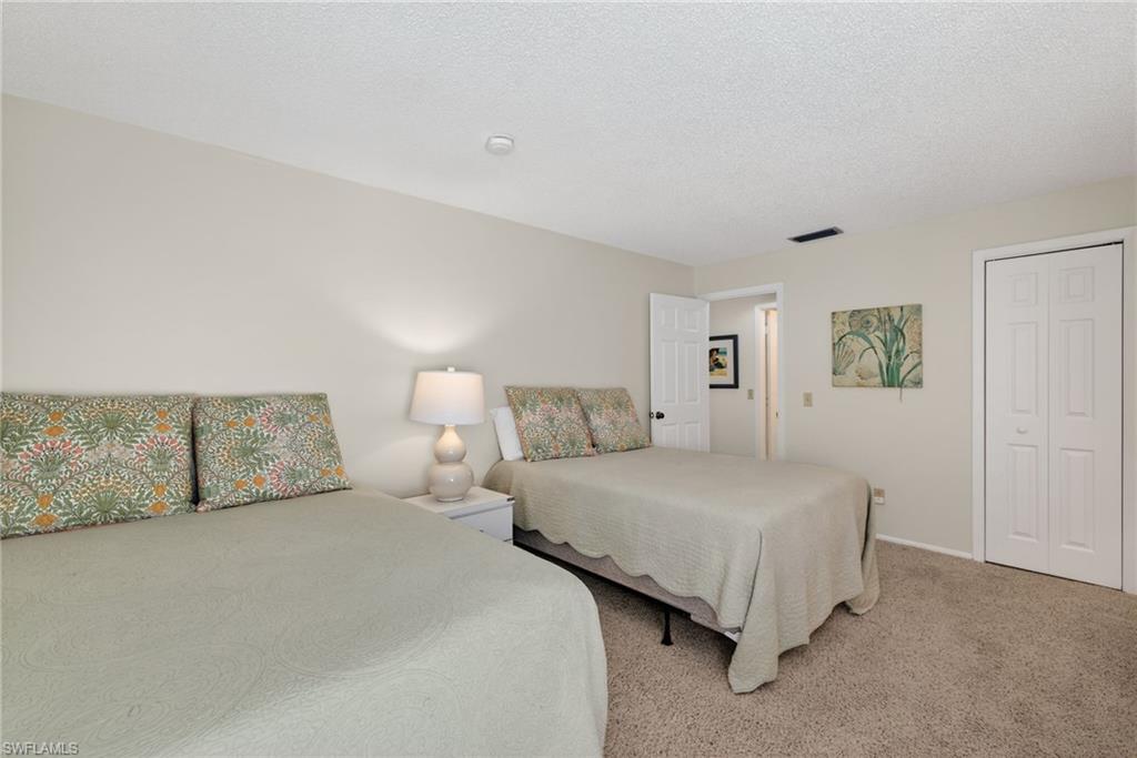 Bedroom with carpet flooring, a textured ceiling, and a closet