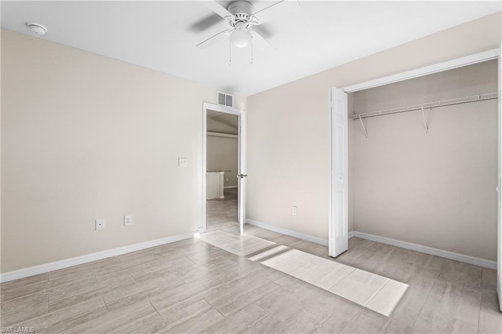 Bright interior space featuring light-toned walls, wood-finish flooring, and a ceiling fan